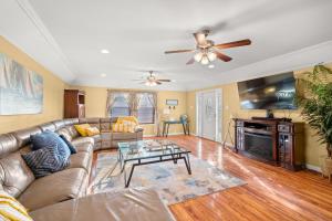 a living room with a couch and a tv at Beachside Getaway - 77 Steps To The Sand in Galveston