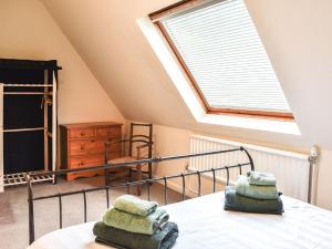 1 dormitorio con 1 cama y ventana con toallas en Janvalyn, en Tregarth