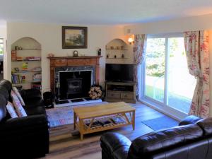a living room with a couch and a fireplace at Feaugh Cottage in Lochgoilhead