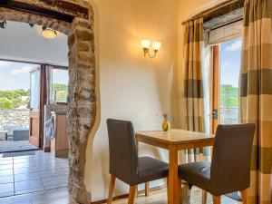 a dining room with a table and chairs and a window at Ravenscliffe Cottage in Tissington
