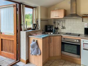 a kitchen with a sink and a stove at Ravenscliffe Cottage in Tissington