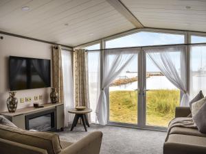 a living room with a large window and a tv at Marina Escape One in Peterhead