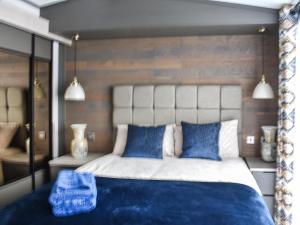 a bedroom with a large bed with blue and white pillows at Marina Escape One in Peterhead