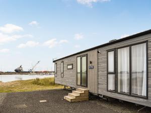 a tiny house parked next to a body of water at Marina Escape One in Peterhead