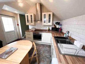 eine Küche mit weißen Geräten und einer hölzernen Arbeitsplatte in der Unterkunft Scottish Highland Cottage Tyndrum Upper Station in Crianlarich