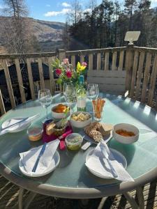 Scottish Highland Cottage Tyndrum Upper Station في كريانلاريش: طاولة زرقاء مع صحون وأطباق طعام عليها
