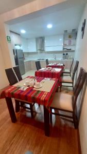 a dining room with a table and chairs and a kitchen at MADA Guest House Puno "Hospedaje" in Puno
