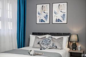 a bedroom with a bed with blue curtains at Cosy 4-Bedroom Apartment next to Borough in London
