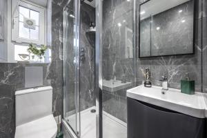 ein Bad mit einer Dusche, einem Waschbecken und einem WC in der Unterkunft Cosy 4-Bedroom Apartment next to Borough in London