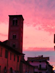 a clock tower on top of a building with a pink sky at B&B San Gregorio in Cherasco
