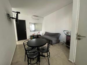 Zimmer mit einem Tisch, Stühlen und einem Sofa in der Unterkunft Hermoso y acogedor departamento Colinas Santiago in Manzanillo