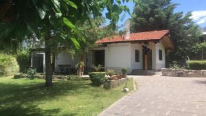 a small white house with a tree in the yard at LA NEGRITA in Ciudad Lujan de Cuyo
