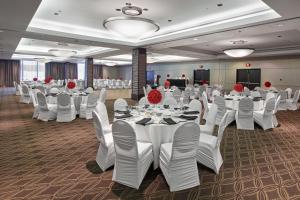 une salle de banquet avec des tables blanches et des chaises blanches dans l'établissement Delta Hotels by Marriott Edmonton Centre Suites, à Edmonton