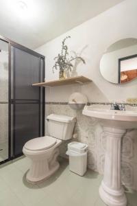 a bathroom with a toilet and a sink at Letto Hostal in Rionegro