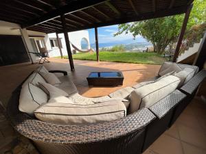 - un canapé en osier installé sur une terrasse dans l'établissement Luxueux VILLA avec jardin et vue panoramique, à Tetouan