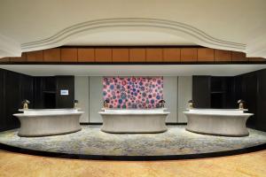 a lobby with two desks and a painting on the wall at Sheraton Surabaya Hotel & Towers in Surabaya