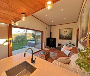 uma cozinha e sala de estar com um sofá e uma mesa em Te Awa Mata o' Tukituki em Havelock North