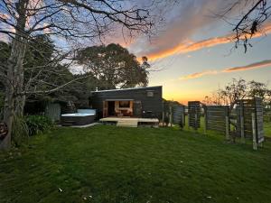 una pequeña casa negra en un patio con una valla en Te Awa Mata o' Tukituki, en Havelock North
