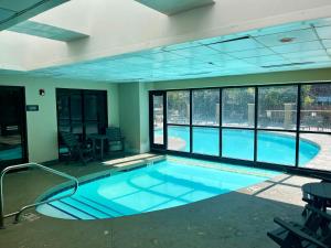 a large swimming pool in a building with windows at MT CB Base Area with King Bed, Outdoor Hot Tub & Pool in Crested Butte