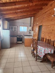 uma cozinha com uma mesa e um frigorífico em Cabaña Amapola, Pichidangui em Pichidangui