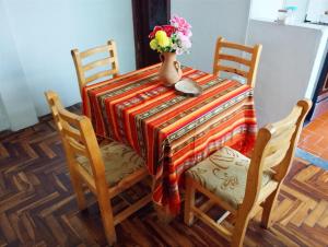 uma mesa com um vaso de flores e duas cadeiras em Villa bonita em Baños