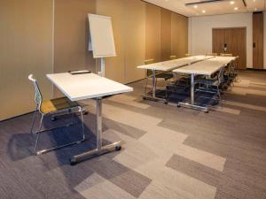 a conference room with tables and chairs and a whiteboard at Novotel Nancy in Nancy