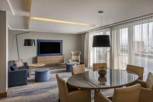 a living room with a table and a tv at Courtyard by Marriott Linz in Linz
