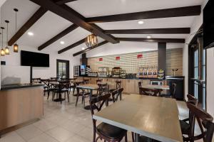 a restaurant with tables and chairs and a bar at Best Western Plus Manhattan Beach Hotel in Manhattan Beach