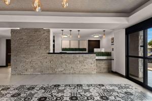 uma cozinha em plano aberto e sala de estar com uma parede de tijolos em Best Western Plus Manhattan Beach Hotel em Manhattan Beach