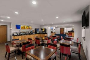 a restaurant with tables and chairs and a kitchen at Comfort Inn & Suites ATX North in Austin