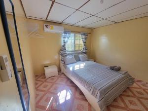 a small bedroom with a bed and a window at Chelox Panama Airport in Cabuya
