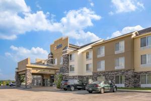 a hotel with two cars parked in a parking lot at Comfort Inn & Suites in Berea