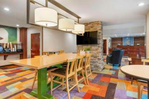 a dining room with a large wooden table and chairs at Comfort Inn & Suites in Berea