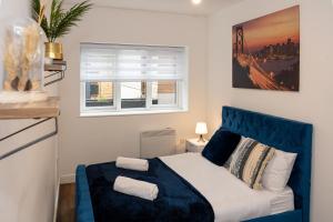 a bedroom with a blue bed and a window at Stunning 2 Bedroom Apartment in Chorlton in Manchester