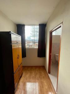 an empty room with a kitchen with a window at Hostal Colonial in Cajamarca