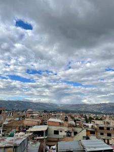 a city with buildings and a cloudy sky at Hostal Colonial in Cajamarca