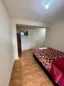 1 dormitorio con 1 cama y TV en Hostal Colonial en Cajamarca