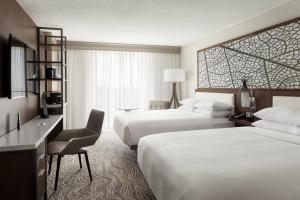 a hotel room with two beds and a desk at Marriott Orlando Airport Lakeside in Orlando