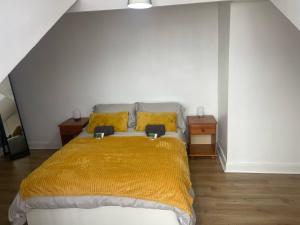 a bedroom with a bed with a yellow blanket at Leeds Serviced Accommodation in Killingbeck