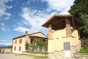 una vieja casa de piedra con una puerta delante de ella en AGRITURISMO VICOLABATE en San Casciano in Val di Pesa