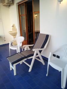 un patio con 2 sillas, un banco y una mesa en Le Giarette, en Cefalú