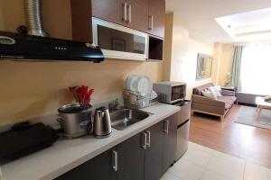 a kitchen with a sink and a living room at 1 BR Condo in East BelAir Residence Cainta Rizal with parking in Manila