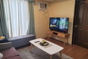 a living room with a flat screen tv and a table at 1 BR Condo in East BelAir Residence Cainta Rizal with parking in Manila