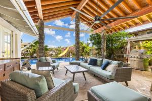 an outdoor patio with furniture and a swimming pool at Tranquil Marina Front Pool House Resort in Honolulu