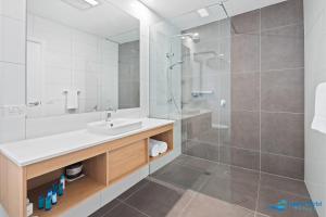 a white bathroom with a sink and a shower at Hive Hotel, Moruya in Moruya