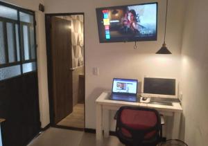 Casa hotel Mi Huila في نيفا: غرفة مع مكتب مع لاب توب وشاشة