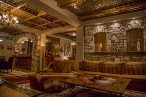 uma sala de estar com um sofá e uma parede de pedra em Pandion Luxury Boutique Hotel & Suites with Spa em Neochori