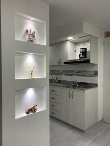 uma cozinha com armários brancos e uma bancada em Agradable apartamento norte calle 170 em Bogotá