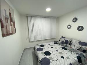 um quarto com uma cama com um cobertor de bolinhas em Agradable apartamento norte calle 170 em Bogotá