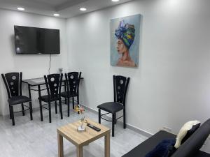 uma sala de espera com uma mesa e um quadro de uma mulher em Agradable apartamento norte calle 170 em Bogotá